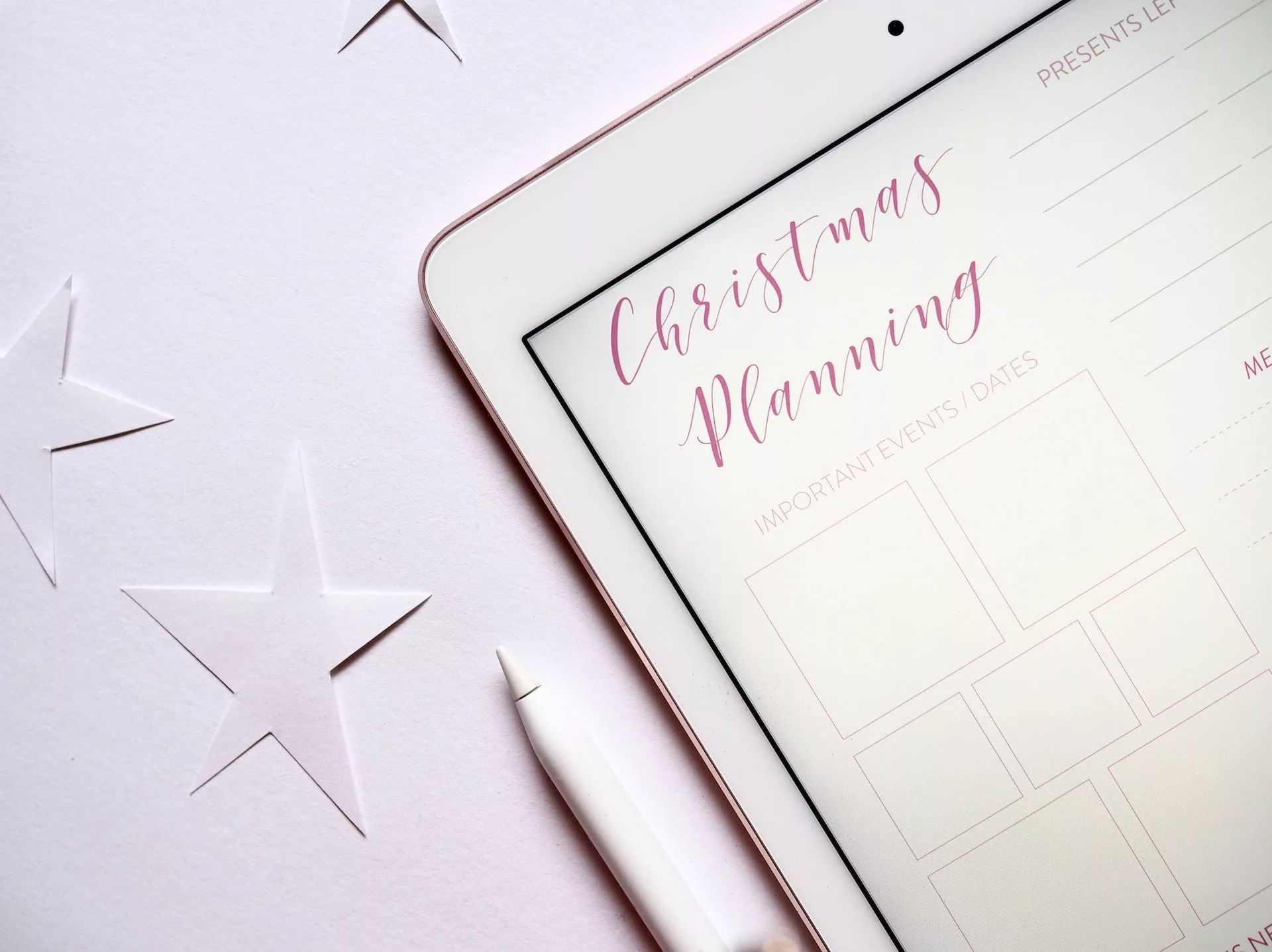 Tablet displaying a christmas planning template with stylus and star decorations symbolizing holiday preparation and seasonal marketing strategy   keybuzz digital marketing services