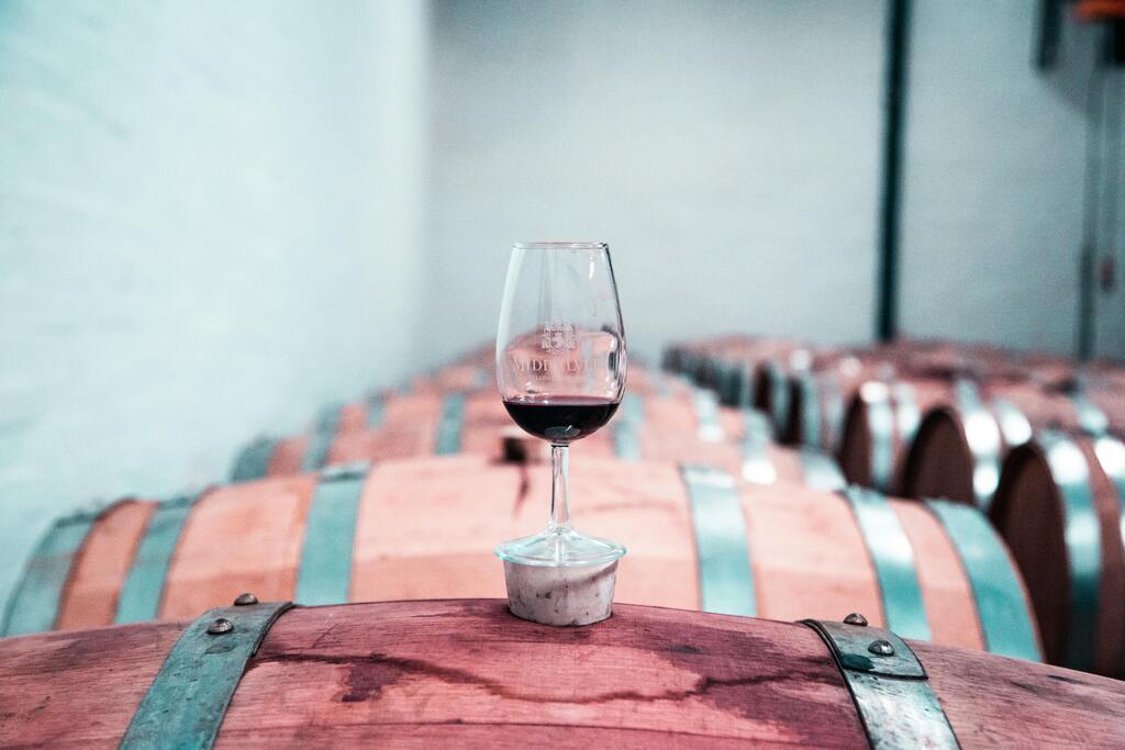 SEO for Vineyards – a glass of red wine on a barrel in a cellar, symbolizing how KeyBuzz Digital blends tradition with modern marketing to grow winery visibility online.