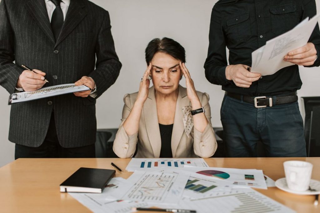 Frustrated small business owner at desk, overwhelmed by digital marketing challenges and an underperforming website.
